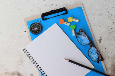Business concept. desk office notepad, glasses, pencil and compass on wooden background. top view