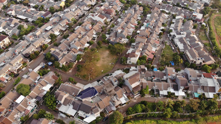 Aerial drone view of one residential at depok city, indonesia, with green fieldの写真素材
