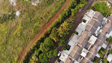 Aerial drone view of one residential at depok city, indonesia, with green fieldの写真素材