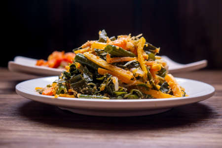 made with boiled vegetables dressed with spiced grated coconut topping called Urap on white plateの写真素材