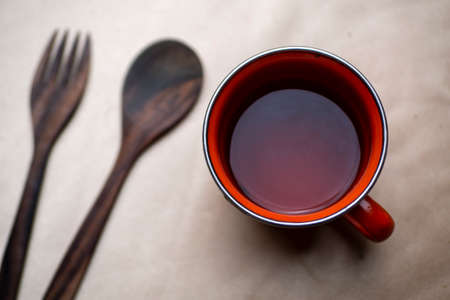 A cup of tea and cutlery, photographed from head close up with golden clothing as backdropの写真素材
