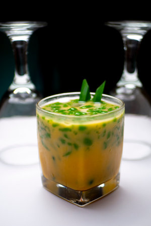 a glass of ice cendol, decorated with a straw, with a glass background placed upside downの写真素材
