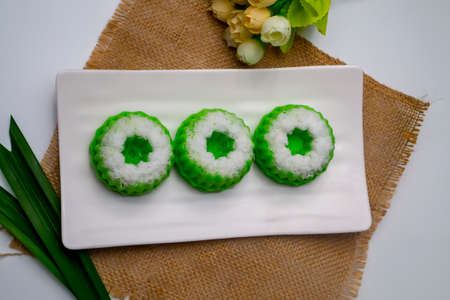 Putu Ayu, Indonesian traditional food, on white plate and white table decorated with plastic flowers