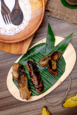 Piscok or Pisang Coklat, Chocolate Banana Crispy, Indonesia cuisine on wooden table and decorated with culteryの写真素材