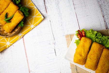 Delicious Risoles or Risol Vegetable is a typical Indonesian traditional street food made from flour skin, meat and vegetables stuffing inside, decorated with chilies and wooden tableの写真素材