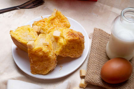 Coconut bread on white plate with a bottle of milk and an eggの写真素材