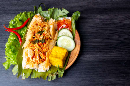 Nasi Bakar, Indonesian traditional food, filled with sliced chicken, decorated with cucumber, fried tofu, and chili sauceの写真素材