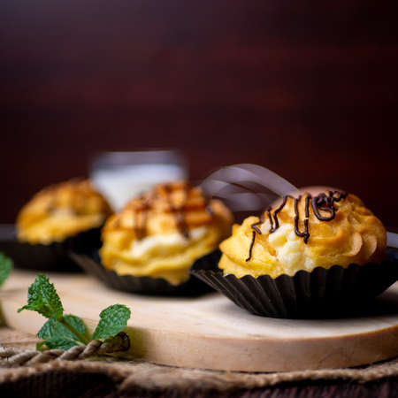 Kue soes coklat, soes coklat, chocolate cream puffs or famous with Choux Pastry Cream Puffs, pastry ball filled with white creamの写真素材