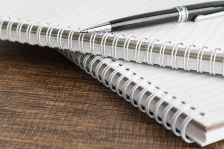 Notepad and pen on the wooden tableの写真素材