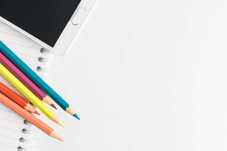 Color pencils, notepad and smartphone on the white backgroundの写真素材