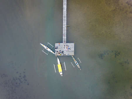 Traditional fishing boat docking on a harbor bridge or jetty in Sulawesi - Indonesiaの写真素材
