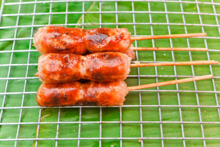 Thai sausage inserts the wood in the marketの写真素材