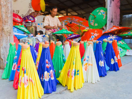 CHIANG MAI, THAILAND - JANUARY 19: Unidentified, Man drawing flowers on paper umbrella, in traditional umbrella factory (Ban Boa -Sang) on January 19, 2014 in Chiang Mai, Thailand.のeditorial素材