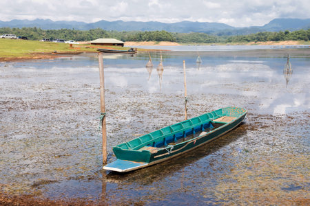 fishing boat on the lake in countryside of thailand with mountain backgroundの写真素材