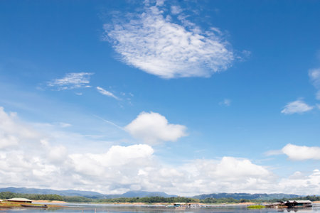 Landscape of a river with a blue sky and white clouds, floating house, Thailand.の写真素材