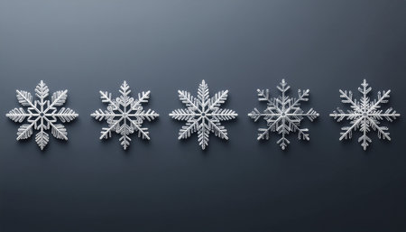 A set of five unique and intricately designed realistic ice crystal snowflakes arranged horizontally on a smooth dark grey surface.のイラスト素材