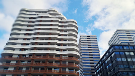 Modern buildings with wavy balconies rising up to the blue sky in the business district