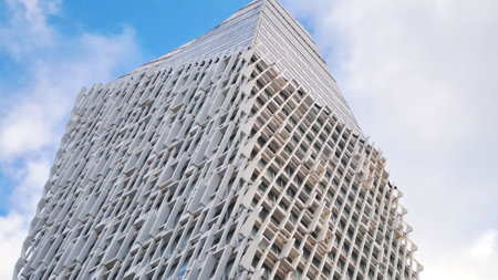 Modern white skyscraper building reaching for the sky on a sunny day in the cityの写真素材