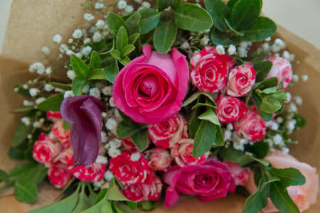 Closeup shot of red bouquet of roses, gerberas, peonies, pomegranates. Love and passion symbol. Anniversary or birthday gift for girl.の写真素材