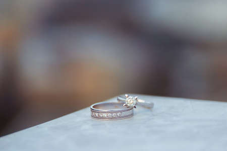 Engagement and wedding rings over each other. Marble on the stone.の写真素材