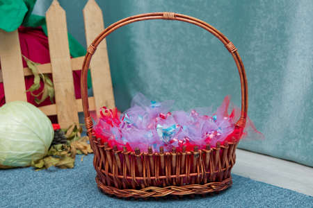 Baskets from the shoulders. candy in the basket. Wicker basket with candies, chocolates and sweets for kids manufactured by different companies. Studio shot.の写真素材