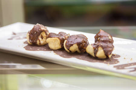 Chocolate cupcakes on plate on table. 4 cakes with chocolate small roundの写真素材