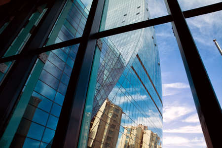 Panoramic and perspective wide angle view to steel light blue background of glass high rise building...