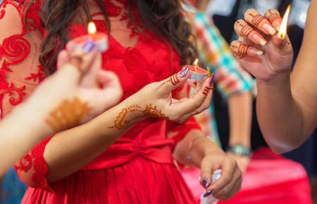 The bride decorated with a decorative candlestick in her hands and a sign . holds a candle in her hand . in the background without focus . The bride has a candle in his hand . Candles burnの写真素材