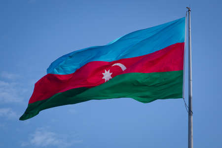 Azerbaijan flag in Baku, Azerbaijan. National flag background. Red Green Blue flag. Azerbaijan national flag with Crescent moon. Azerbaijan tradition patriotic. Flags waving wind. Flags stand wavingの写真素材