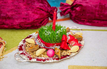 Novruz national Azerbaijan holiday spring new year celebration concept, wheat grass semeni . A seminal siege on a red ribbon on a dry grassの写真素材