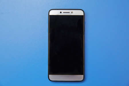 Black mobile smart phone mock up. This smartphone mock-up isolated on blue background. black smartphone with black screen. mobile phone . Can use for printing, website, presentation element.の写真素材