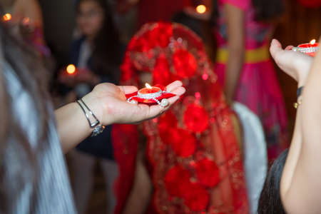 She holds the candle in his hand Henna party . Holding hands on henna candle .の写真素材