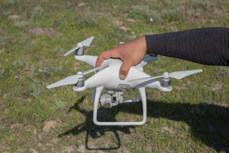 White drone with digital camera flying in sky over mountain Drone with high resolution digital...