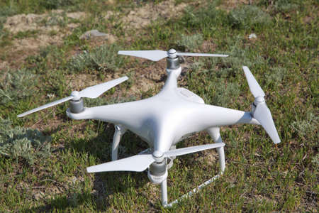 White drone with digital camera flying in sky over mountain Drone with high resolution digital...