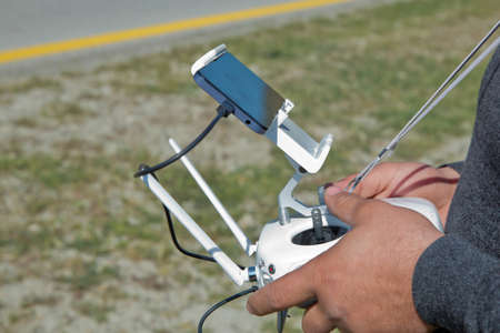 White drone with digital camera flying in sky over mountain Drone with high resolution digital...