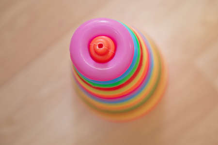 Pyramid build from colored wooden rings with a clown head on top. Toy for babies and toddlers to joyfully learn mechanical skills and colors.の写真素材