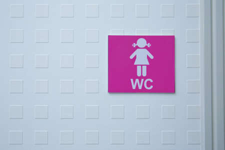 Restroom sign on a toilet door. WC Toilet icons set. Women WC signs for restroom. Women's Bathroom Icon Sign Restroom or Toilet room on the cement wall .の写真素材