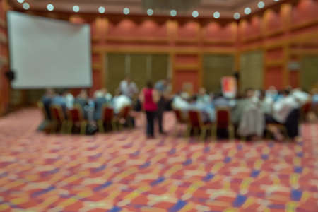 Blurred photo of audience group attending in conference meeting room. Group of business people...