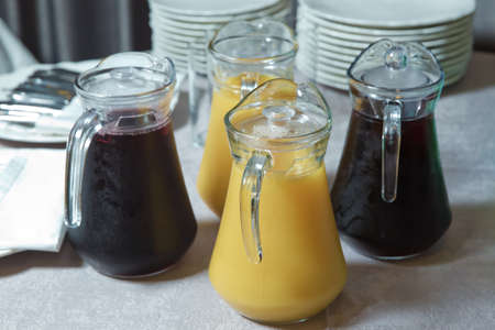 yellow and red smoothie juice . Delicious orange juice in jug . uice in heavy glass jug Orange . Yellow and red Glass Pitcher .の写真素材
