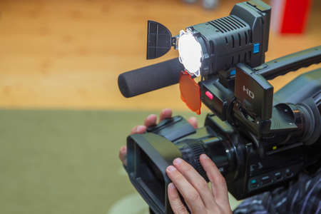 Covering an event with a video camera., Videographer takes video camera with free copy space for...