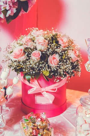 Rounded pink flower bouquet. Bouquet of delicate pink flowers in round boxes. Stairs and chair on the white with lots of bouquets of pink flowers.の写真素材