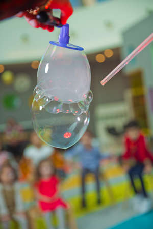 Childrens party. To burst the soap bubble . Soap bubbles show.