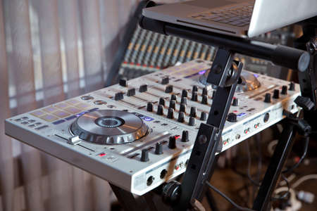 Dj mixes the track in the nightclub at party . Headphones in foreground and DJ hands in motion ....