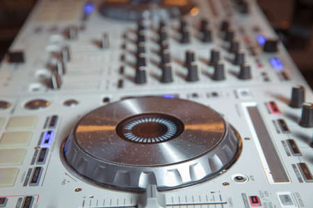 Professional concert dj turntables player device with sound mixer panel and jog wheel.Club disc jockey stage equipment for playing music on party.Digital turn table deck for nightclubの写真素材