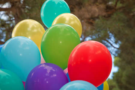 Colorfull balloons flying in the sky. Bunch of colorful balloons in the green background . many colorful balloons for the outdoor partyの写真素材