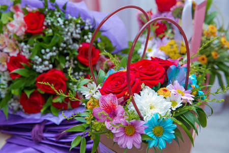 Paper bouquet of fresh red, white , blue, purple roses . Paper bouquet of multicolored roses . Pink, red flower picture close up in the bouquet.の写真素材