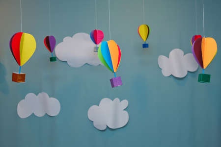 Hanging from above Colorful paper balloon with blue sky background and clouds. Origami made colorful air balloon cloud.の写真素材