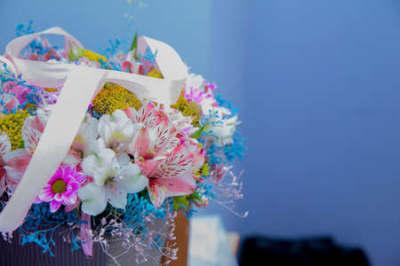 Bouquet of multicolored roses . Pink flower picture close up in the bouquet. Ribbon . Bouquet of fresh Pink, white , blue, orange roses .の写真素材