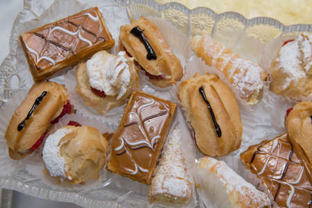 Ekler Pasta Chocolate Donut in plate. A lot of french dessert of profiteroles eclair choux pastry.