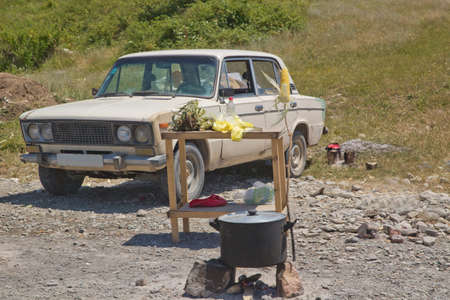 Vintage green russian soviet automobile at the city street . They sell the cabbage on the edge of the road .Cook corn in the boiler.Boiled corn in the big boiler . old Soviet machineの写真素材
